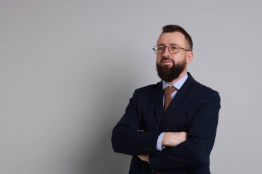 Gri arka planda takım elbiseli yakışıklı sakallı adam. Metin için boşluk