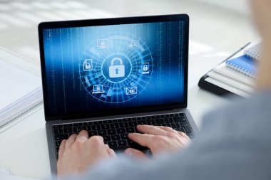 Siber güvenlik. Beyaz masada dizüstü bilgisayar kullanan adam, yakın plan.