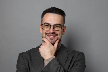 Gri arka planda orta yaşlı yakışıklı bir adamın portresi.