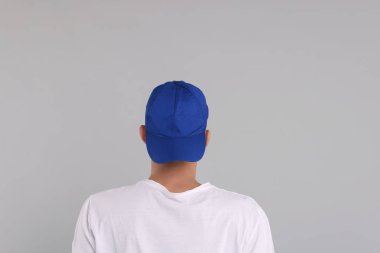 Beyzbol şapkalı, gri arka planda, arka planda bir adam. Tasarım için model
