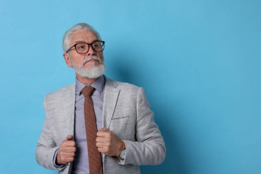 Açık mavi arka planda gri sakallı yaşlı adamın portresi. Metin için boşluk