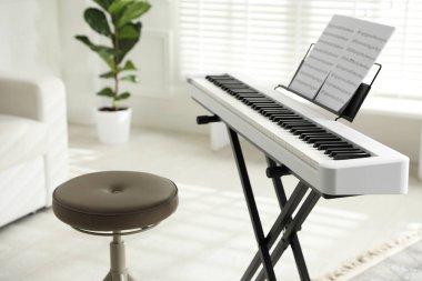 Evde müzik kağıtları ve taburesi olan sentezleyici, kapat