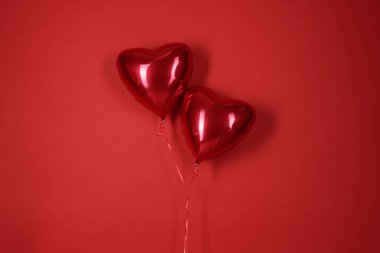 Kırmızı arka planda kalp şeklinde balonlar. Sevgililer Günü