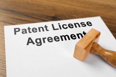 Patent Lisansı Sözleşme metni ve damga aracı ahşap masa üzerinde, yakın plan