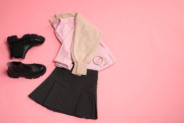 Pembe arka planda şık elbiseler, botlar ve aksesuarlar, düz yatış. Metin için boşluk