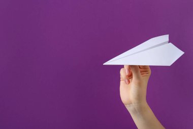 Mor arka planda beyaz kağıt uçaklı kadın, yakın plan. Metin için boşluk