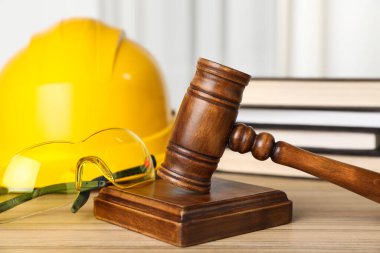 İşte bir kaza oldu. Gavel, gözlük, şapka ve kitap yığını ahşap masa, yakın plan.