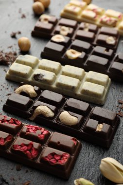 Fındıklı çikolatalar ve siyah masada kurutulmuş ahududu, yakın plan.