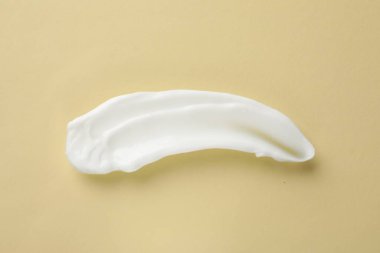 Bej arka planda vücut kremi lekesi, üst manzara.