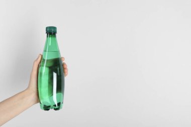 Arka planda plastik su şişesi tutan kadın, yakın plan. Metin için boşluk