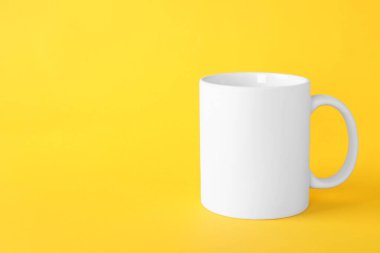 Sarı arka planda beyaz bir kupa. Tasarım için model