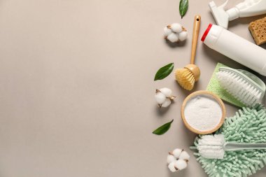 Farklı temizlik ürünleri, aletler, pamuk çiçekleri ve bej arka planda yapraklar, düz yatak. Metin için boşluk