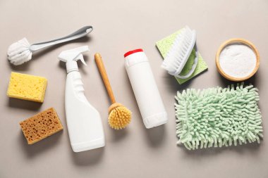 Farklı temizlik ürünleri, araçlar, pamuk çiçekleri ve bej arka planda yapraklar, düz uzanma