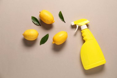 Bej arka planda sprey temizleme ürünü ve limon içeren düz kompozisyon.