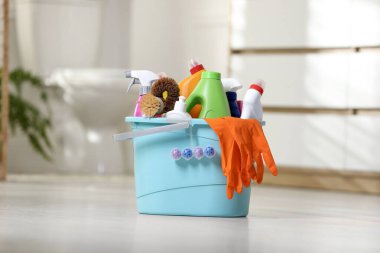 Banyoda yerde farklı temizlik malzemeleriyle dolu bir kova.