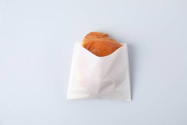 Beyaz arka planda taze pişmiş ekmeği olan kağıt torba, üst manzara.