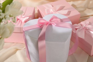 Güzel düğün hediyeleri ve ipek kumaş üzerinde çiçekler, yakın plan.