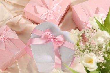 Güzel düğün hediyeleri ve ipek kumaş üzerinde çiçekler.