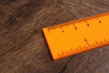 Bir portakal renkli cetvel ahşap masada, yakın plan. Metin için boşluk