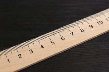 Bir cetvel siyah ahşap masada, yakın plan.