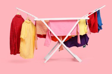 Açık pembe arka planda temiz çamaşırlı kuru askı.