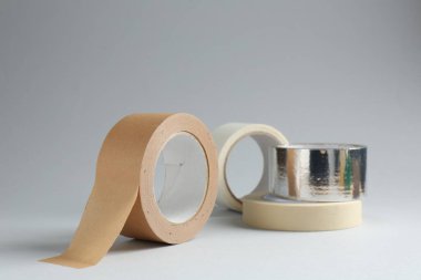 Gri arkaplanda farklı yapışkan bantların ruloları