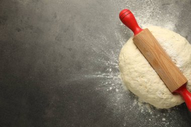 Taze hamur ve yuvarlak raptiye gri masada, üst manzara. Metin için boşluk