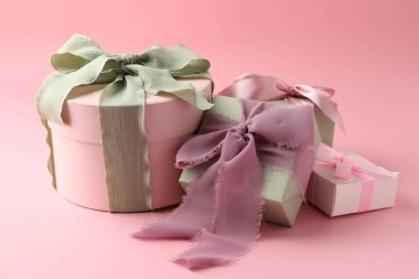 Pembe arka planda güzel fiyonklu farklı hediye kutuları.