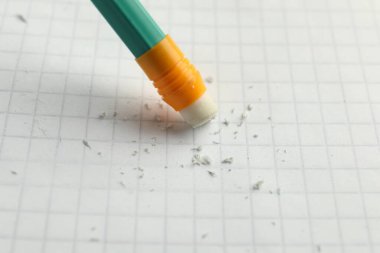 Beyaz kağıt üzerine silgi ile kalem kullanarak, yakın plan