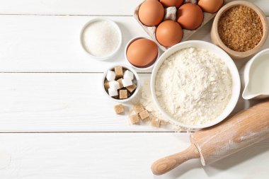 Hamur için merdane ve malzemeler beyaz ahşap masada, düz yerde. Metin için boşluk