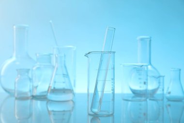 Ayna yüzeyinde açık mavi arkaplana karşı laboratuvar camları