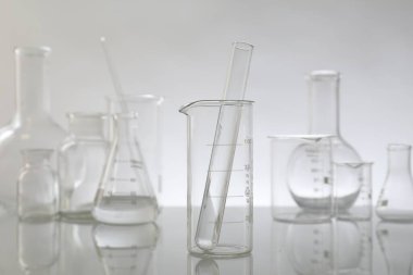 Ayna yüzeyinde ışık arkaplanına karşı laboratuvar camları