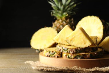 Tahta masada olgun ananas dilimleri, yakın plan. Metin için boşluk