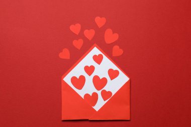 Sevgililer Günü. Kırmızı arkaplanda birçok kağıt kalpli zarf, üst görünüm