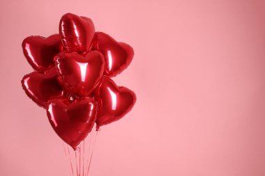 Pembe arka planda bir sürü kırmızı kalp şeklinde balon, mesaj için boşluk. Sevgililer Günün kutlu olsun.