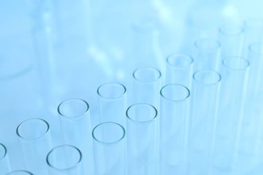 Açık mavi arka planda boş test tüpleri, yakın plan. Laboratuvar camları.