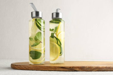 Nane aromalı limon suyu ve bej masadaki salatalık dilimleri, metin için yer.