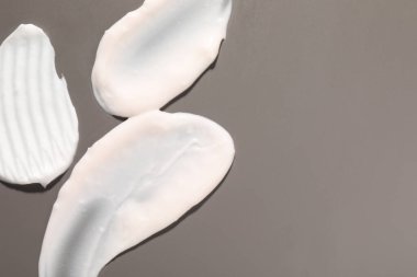 Pembe arka planda krema, düz yatak ve metin için boşluk. Kozmetik ürün örnekleri