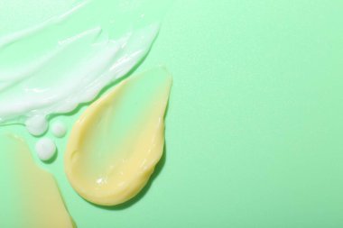 Açık yeşil arka planda krem örnekleri, üst manzara. Metin için boşluk