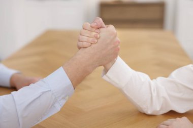 Rekabet konsepti. İş adamları ofiste bilek güreşi yapıyor, yakın plan.