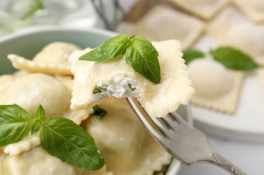 Peynirli ravioli ve çatallı fesleğen dolu kâseye karşı, yakın plan.