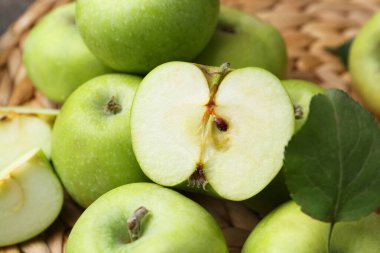 Hasır hasırın üzerinde tüm yeşil elmaları kes, yakın plan.