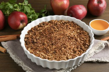 Lezzetli elmalı gevrek ve ahşap masada malzemeler, yakın plan.