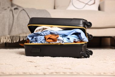 İçerde farklı kıyafetlerle dolu bir bavul aç.