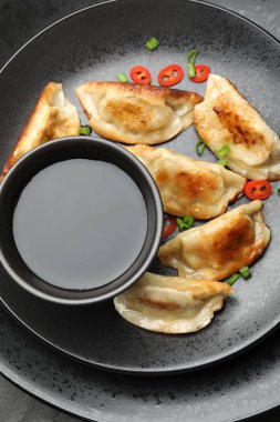 Kızarmış gyoza köftesi, yeşil soğan, kırmızı biber ve soya sosu.