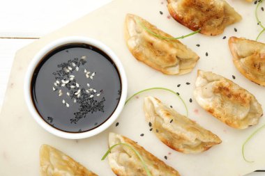 Beyaz masada servis edilen susamlı lezzetli kızarmış gyoza köfteleri.