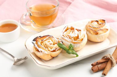 Nane, bal, tarçın çubukları ve beyaz mermer masada çay ile taze pişmiş elma gülleri, yakın plan.