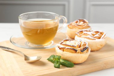 Nane şekerli taze elma gülleri ve beyaz masada çay, yakın plan.