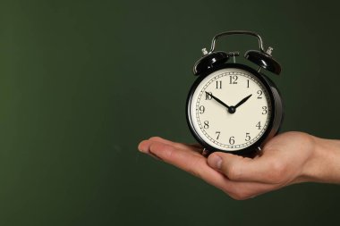 Siyah alarmlı adam koyu yeşil arka planda, yakın plan. Metin için boşluk