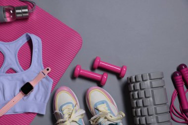 Farklı spor aletleri ve gri arka planda kol saati, düz yatış. Metin için boşluk